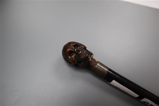 An ivory metamorphic skull cane handle, length 23.5cm